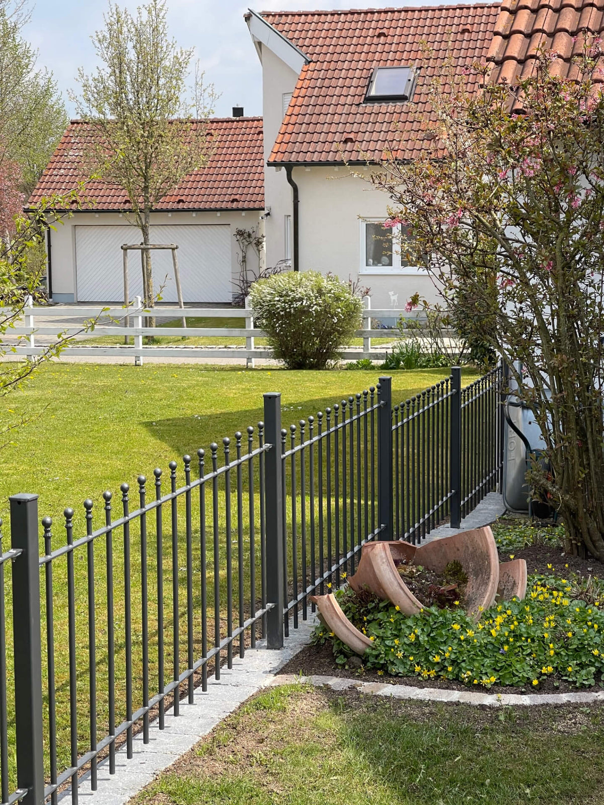 Zaun Ancona höhenversetzt montiert in einem gepflegten Garten | Pulverbeschichtet anthrazit